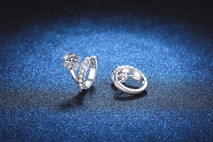 Macro shot of S925 silver moissanite hoop earrings on a luxury dark blue background