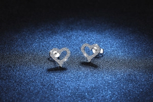 Macro detail of S925 sterling silver heart earrings with sparkling D color moissanite