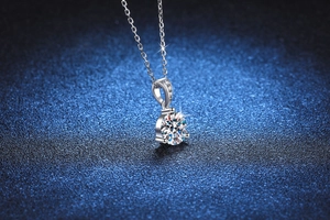 Gros plan d'un collier en argent 925 avec pendentif moissanite sur fond bleu foncé