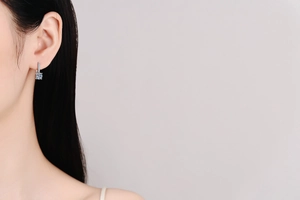 Vue latérale de boucles d'oreilles en argent S925 avec moissanite sur une femme