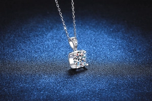 Close-up of D-color 1 carat moissanite pendant necklace with silver ox head prong setting