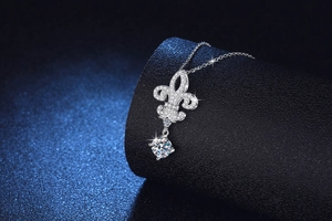 Macro shot of silver fleur-de-lis pendant with round brilliant moissanite stone
