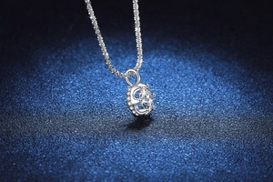 Macro shot of S925 sterling silver crown pendant with 1ct moissanite on blue background