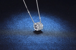 Gros plan d'un pendentif cylindrique pavé de diamants sur chaîne maille miroir