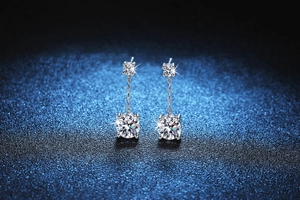 Macro detail of S925 sterling silver drop earrings with brilliant round moissanite stones