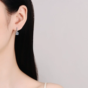 Boucles d'oreilles clous moissanite en argent S925 portées par un mannequin style élégant