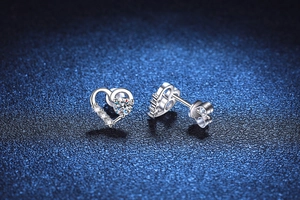 Makroaufnahme von Herz-Ohrsteckern aus Silber mit funkelnden Moissanit-Diamanten