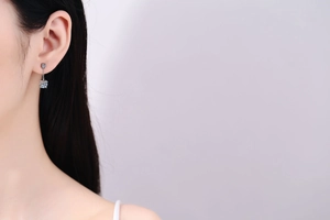 Close-up of S925 silver moissanite tassel earring worn by female model with elegant finish