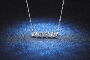 Detailed view of S925 silver necklace with five sparkling moissanite stones in a spiral bar