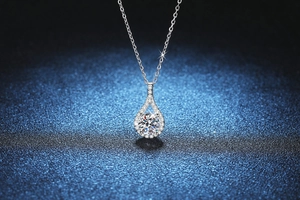 Macro view of teardrop pendant necklace featuring a brilliant round center stone