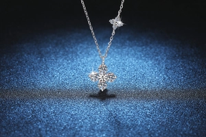 Détail du pendentif trèfle en argent s925 avec moissanite 1,2 ct et breloque fleur latérale