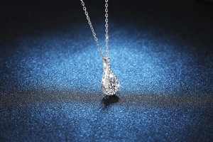 Detailed view of teardrop Moissanite pendant in S925 silver on dark blue background