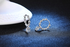 Detail view of 925 silver beaded hoop earrings with heart charm and moissanite stone