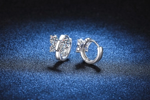 Détail macro de créoles papillon en argent avec des pierres de moissanite brillantes