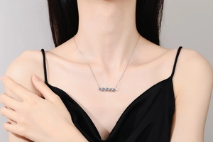 Close-up of elegant S925 silver necklace with five light blue moissanite stones on model