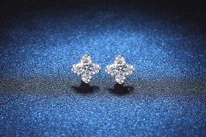 Detailed close-up of S925 silver four-leaf clover stud earrings with moissanite stones