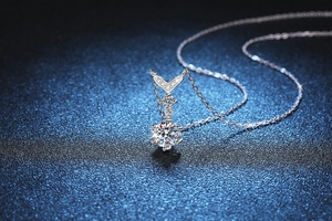 Detailed side view of V-shaped 925 silver fishtail pendant with moissanite in six-prong setting