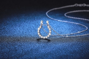 Detailed macro view of S925 sterling silver horseshoe pendant with moissanite diamonds