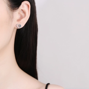Elegante s925 Silber Herz Ohrstecker mit funkelndem Moissanit am Ohr des Models