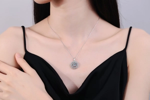 Close-up of a S925 sterling silver double halo moissanite pendant on a model's neck