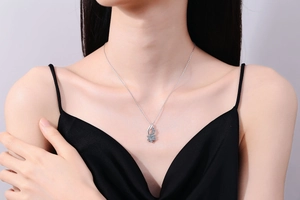 Close-up of S925 silver sunflower necklace with a light blue round-cut moissanite pendant