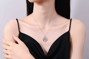 Close-up of S925 sterling silver windmill necklace with sparkling moissanite on model