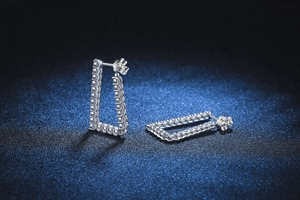 Macro detail of silver S925 moissanite rectangular earrings with sparkling crystal stones