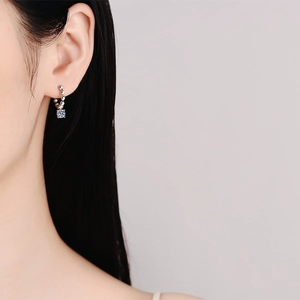 French style silver beaded moissanite hoop earrings worn by a model in a close-up shot