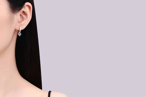 Close-up of a s925 silver earring with a round brilliant-cut moissanite on a model