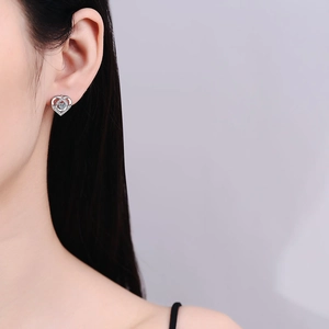 Elegant S925 sterling silver heart-shaped moissanite stud earrings on a female model