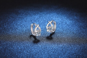 Macro shot of silver teardrop moissanite earrings with pavé setting and brilliant shine