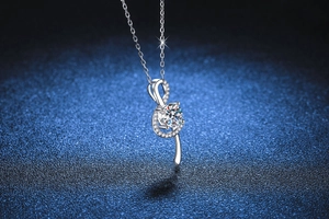 Macro shot of silver musical note necklace with moissanite stone on blue background