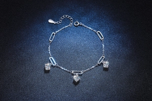 Detail view of S925 silver bracelet with three round sparkling moissanite stone charms