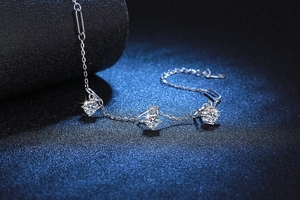 Macro view of three D-color moissanite stones on a 925 sterling silver chain