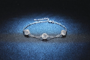 Macro shot of silver paperclip chain bracelet featuring three halo-set moissanite stones