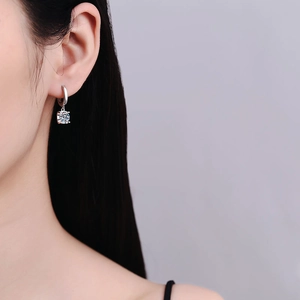 Minimalist S925 sterling silver moissanite hoop earrings worn by a model on a grey background