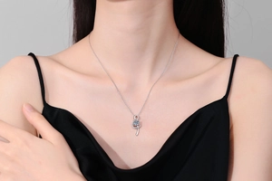 Detail of S925 silver treble clef necklace with 1 carat moissanite on model