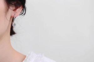 Model wearing elegant S925 silver teardrop earrings with sparkling moissanite stones