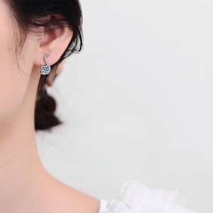 Elegant S925 sterling silver S-shaped moissanite stud earring worn by a model in close-up