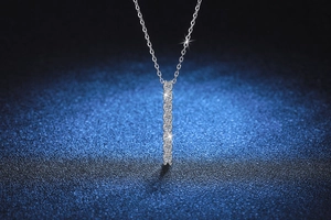 Gros plan d'un pendentif vertical en argent S925 avec moissanite sur fond bleu