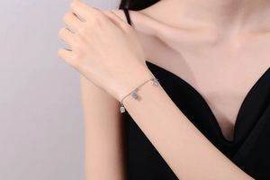Detail of s925 silver bracelet featuring three sparkling square moissanite charms on wrist