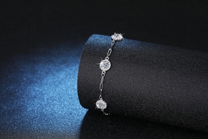 Macro detail of S925 silver paperclip chain bracelet with three sparkling round moissanites