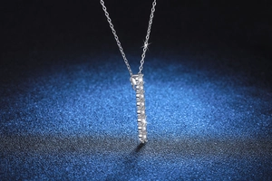 Pendentif vertical en argent S925 avec pierres Moissanite sur un fond bleu profond