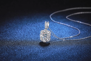 Macro view of the sparkling flower-shaped moissanite pendant on a fine silver O-chain