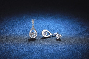 Macro detail of S925 sterling silver teardrop earrings with halo moissanite settings