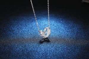 Detailed view of Guardian Wings heart pendant with sparkling Moissanite diamond center