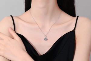 Close-up of S925 silver necklace with four-leaf clover moissanite pendant on model