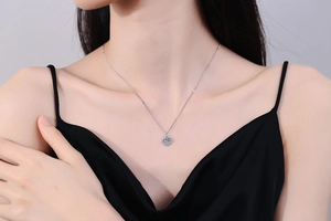 Close-up of S925 silver moissanite necklace with square pendant on black dress