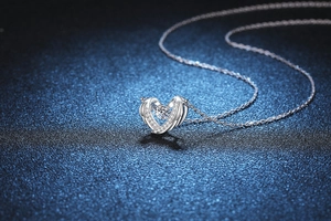 Close-up of s925 silver heart wing pendant with a sparkling round-cut moissanite stone