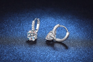 Macro shot of 2ct round moissanite hoop earrings in silver with luxury blue background
